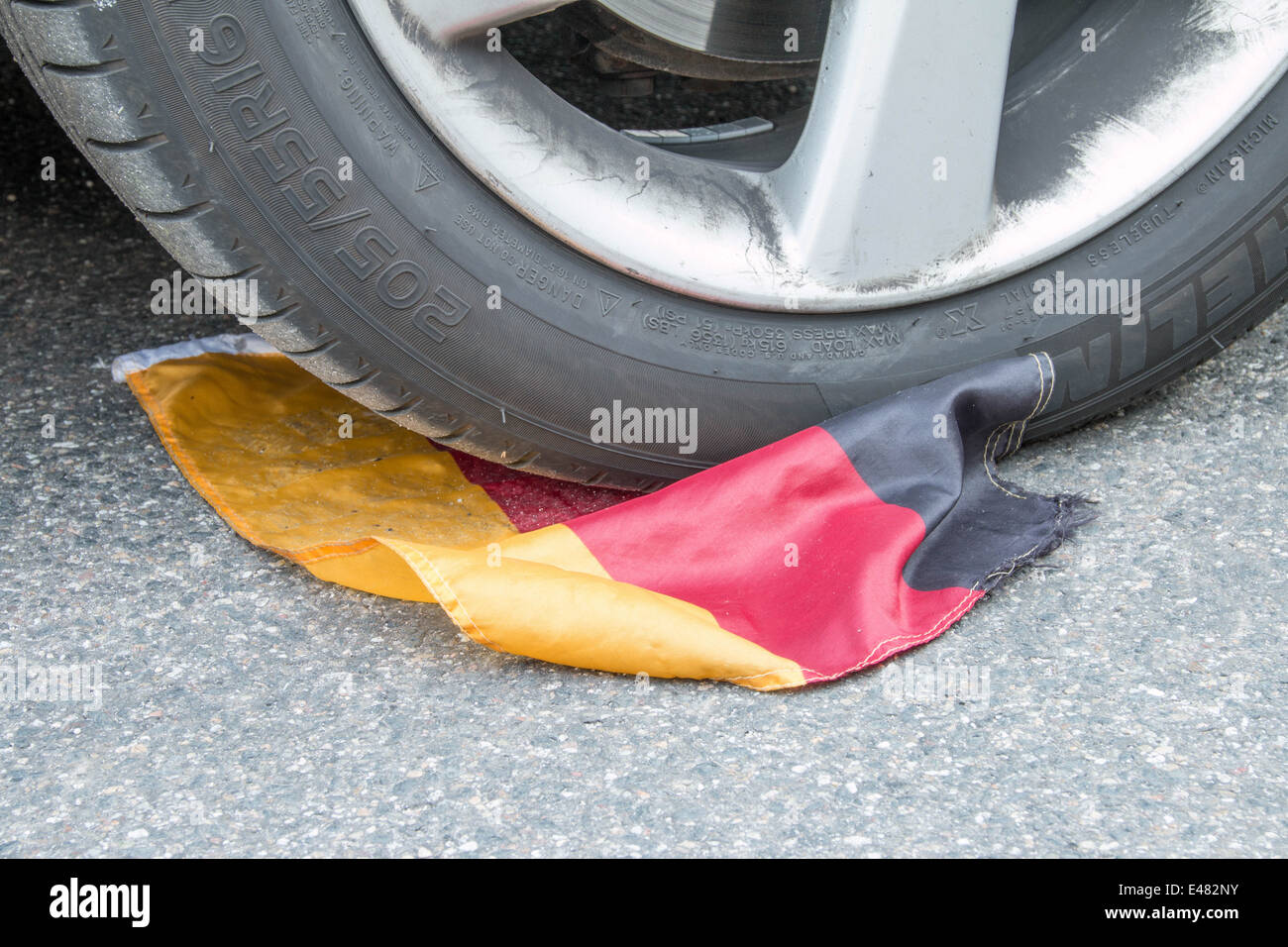 German Soccer Flag under Tire with Tire Tracks Stock Photo