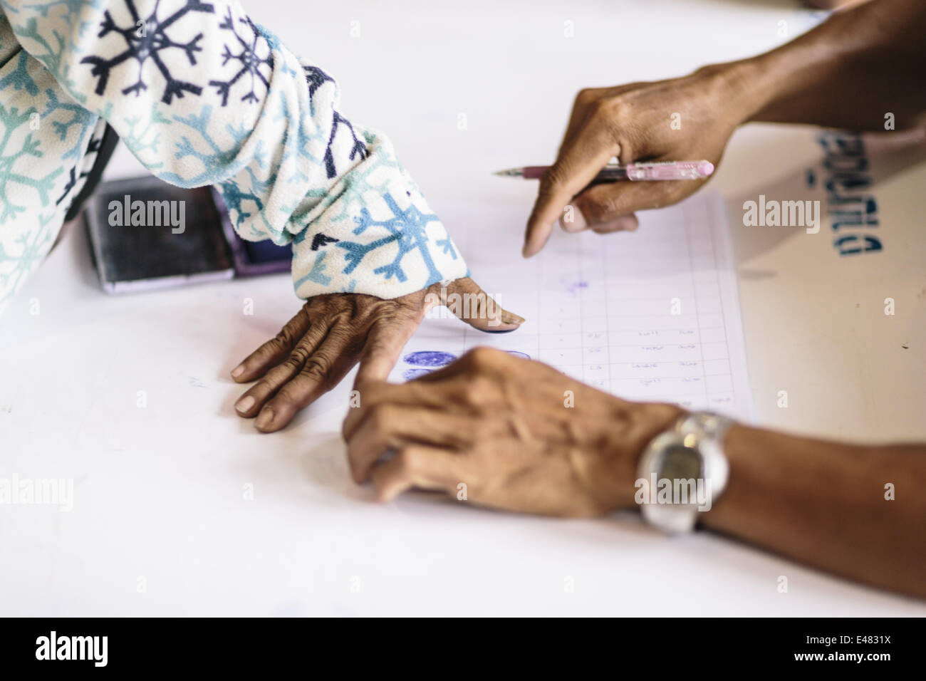 June 16, 2014 - Aranyaprathet/Poipet, Sa Kaeo Province, Thailand - Migrant Cambodian workers register their names and leave their fingerprints with Thai military personnel before they are transported to the border and return home during a mass exodus of Cambodian immigrants from Thailand, Aranyaprathet Town Centre, Aranyaprathet/Poipet, Thailand. Fearing a crackdown on illegal immigration from the Thai military, over 120,000 Cambodian migrants are reported to have crossed the border and returned to Cambodia in one week. Estimates suggest that at least 150,000 legal and illegal migrants from Ca Stock Photo