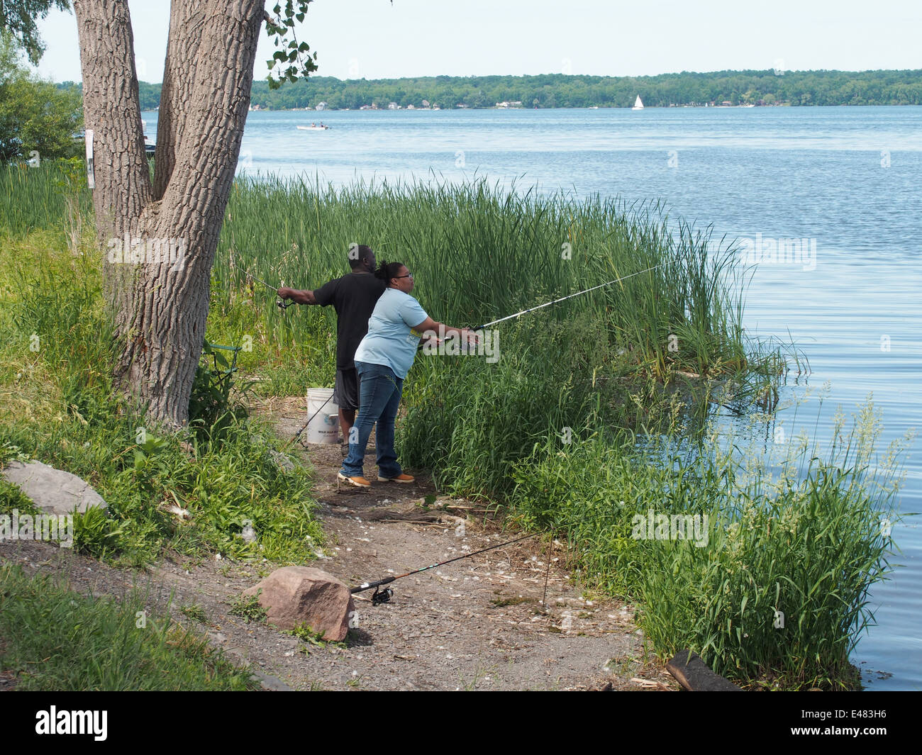 African American man and woman fishing in Cayuga Lake, New York, USA, June 15, 2014, © Katharine Andriotis Stock Photo