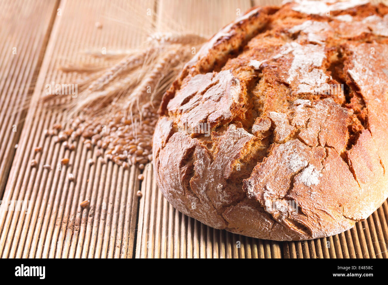 Fresh bread with wheat on the wooden background Stock Photo