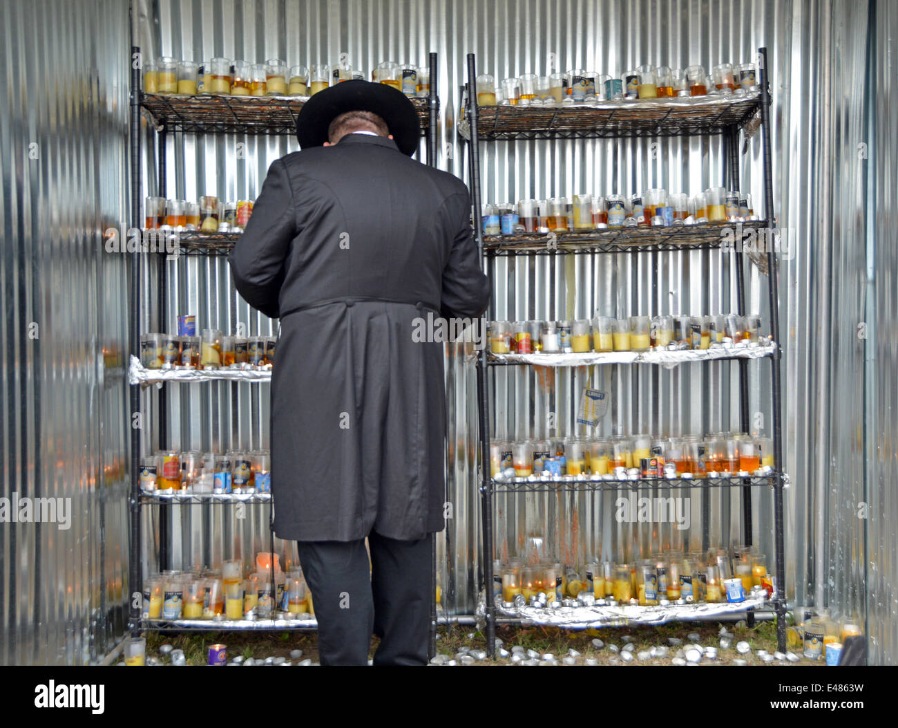 Religious Jewish man lights a candle on the anniversary of the death of