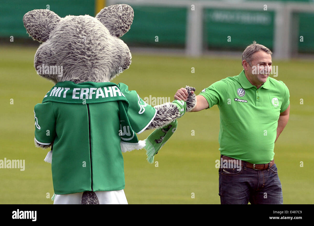 Mascot Woelfi and sports manager Klaus Allofs stand during the practise session that kick-offs the pre-season training of German Bundesliga club VFL Wolfsburg, Wolfsburg, Germany, 05 July 2014. Photo: Peter Steffen/dpa Stock Photo