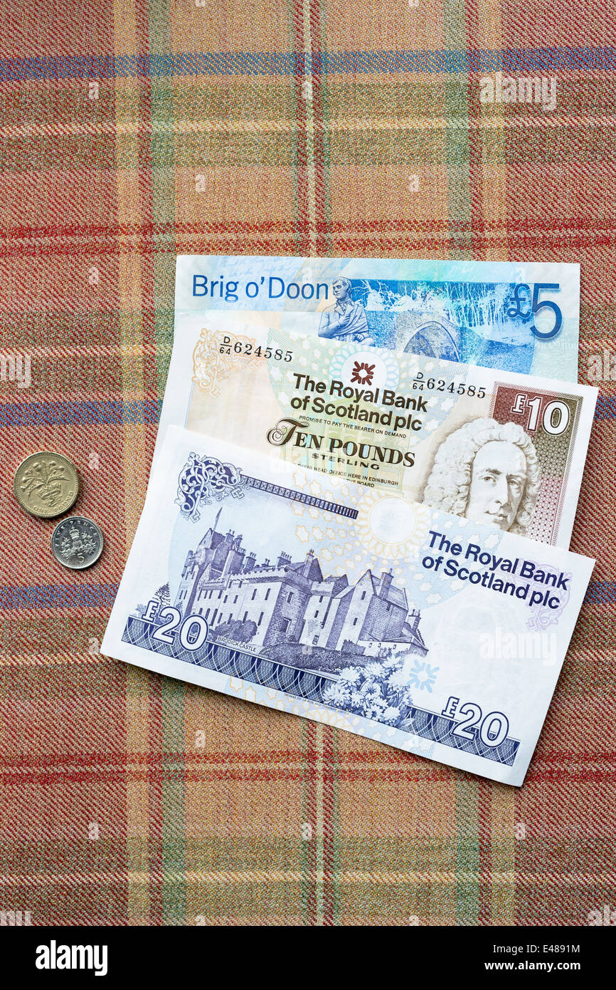 Scottish banknotes from The Royal Bank of SCOTLAND £5, £10 £20 £1 5p coins on traditional Scottish tartan background Stock Photo