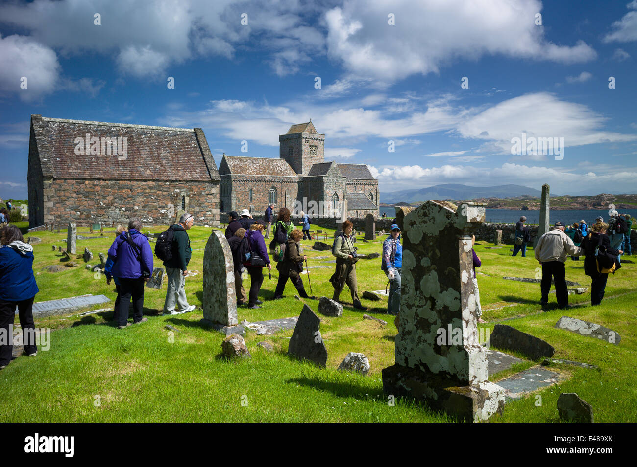 Tourists visiting the St Oran's Cemetery, Reilig Odhrain, where kings and clan chiefs are buried on Isle of Iona in Scotland Stock Photo