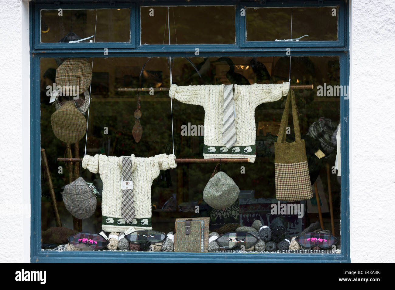 Harris tweed and traditional tartan items display for sale in shop window of gift and souvenir shop on Isle of Iona in Scotland Stock Photo