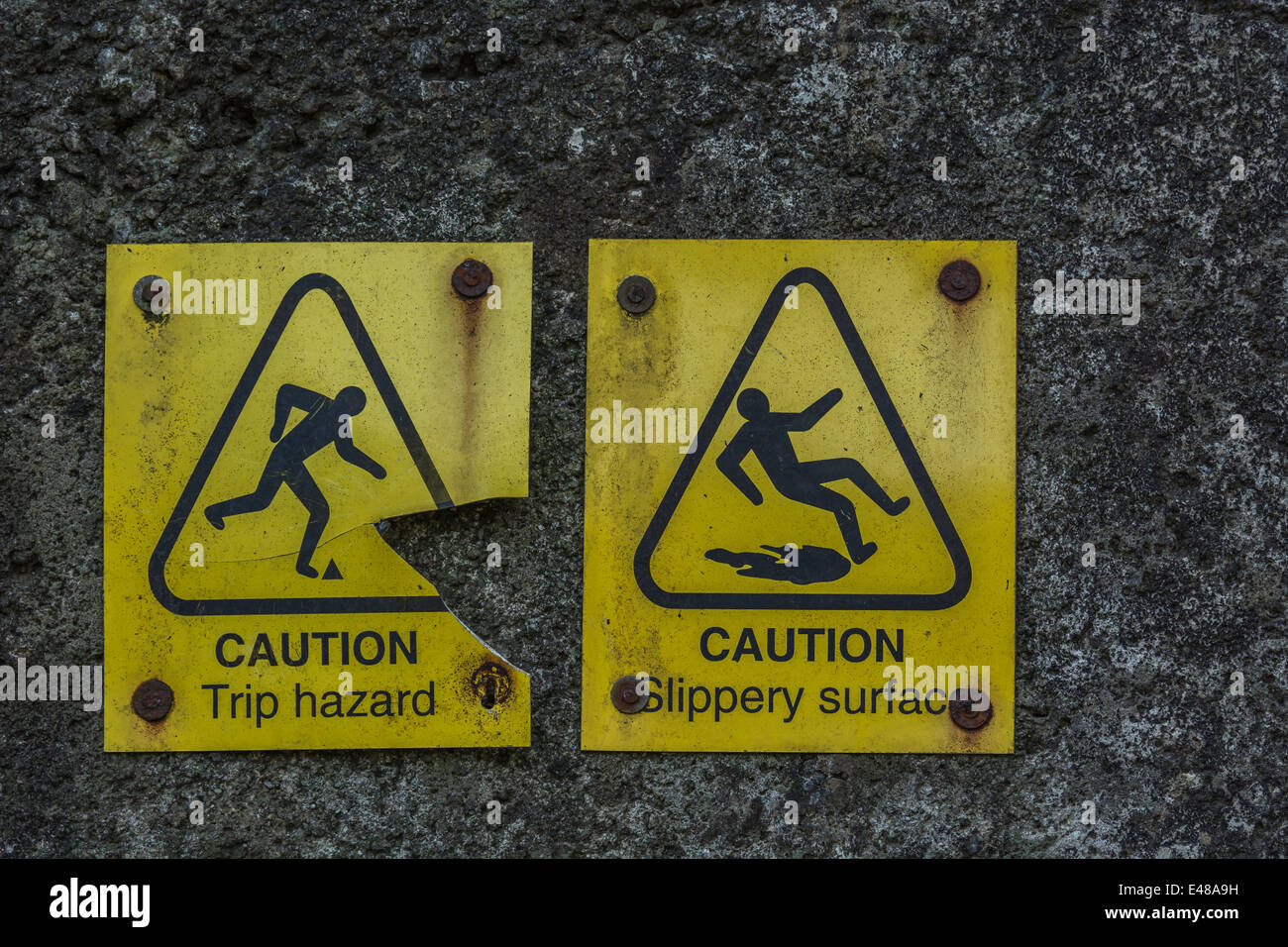 Close detail of two accident warning signs for 'trip' and 'slipping'. Falling man pictogram. Stock Photo