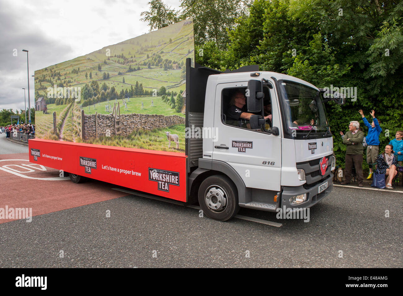 Burley-In-Wharfedale, Yorkshire, July 5th 2014. The Yorkshire Tea float lorry (vehicle in promotional caravan) drives past happy, excited faces of crowds of people lining the route of the Tour De France. Credit:  Ian Lamond/Alamy Live News Stock Photo