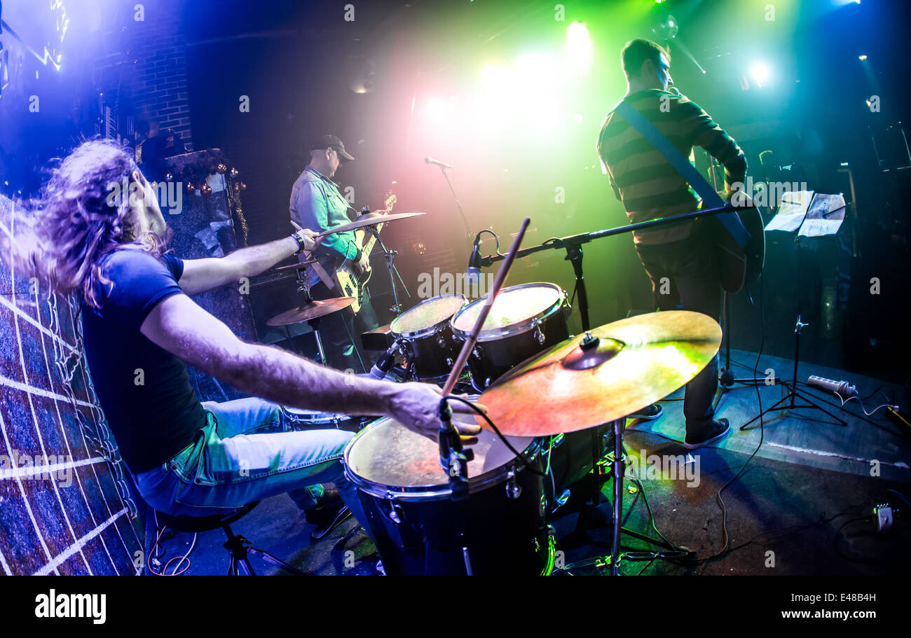 Drummer (blurred motion) playing on drum set on stage. Focus on the ...