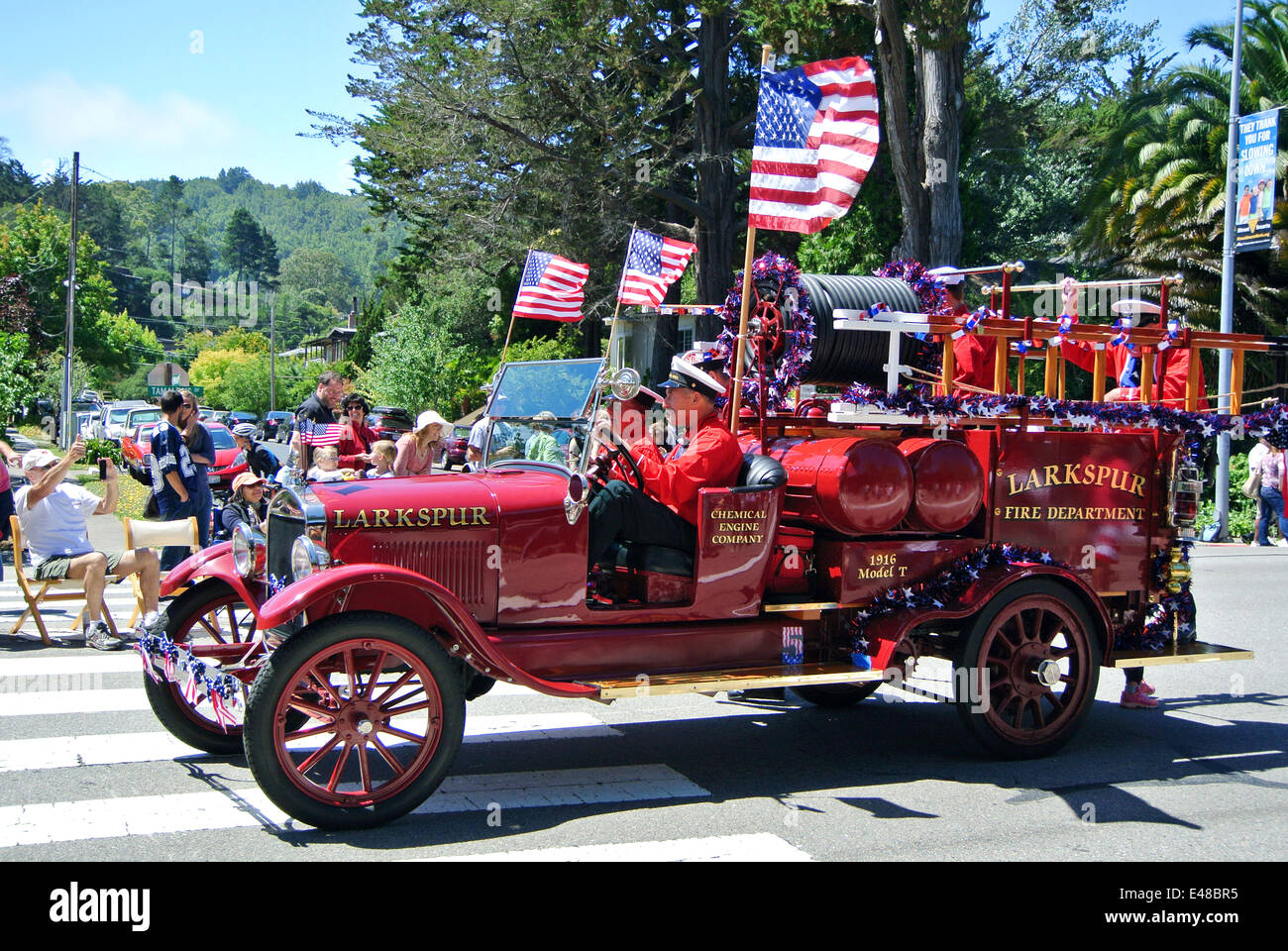 Corte Madera, California, US. July 4th 2014. Larkspur firemen drive 1916 Model T ford fire engine in the annual independence day parade in Corte Madera, California. Credit:  Bob Kreisel/Alamy Live News Stock Photo