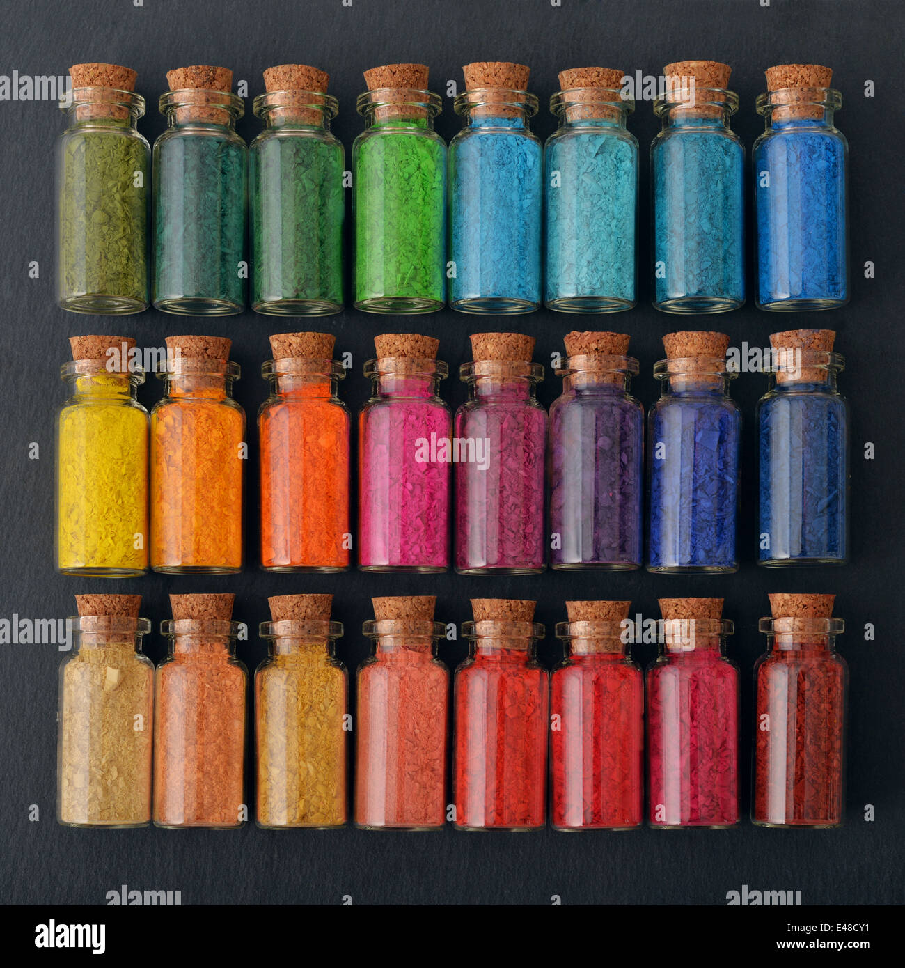 Bottles with colored powder dyes on a black background Stock Photo