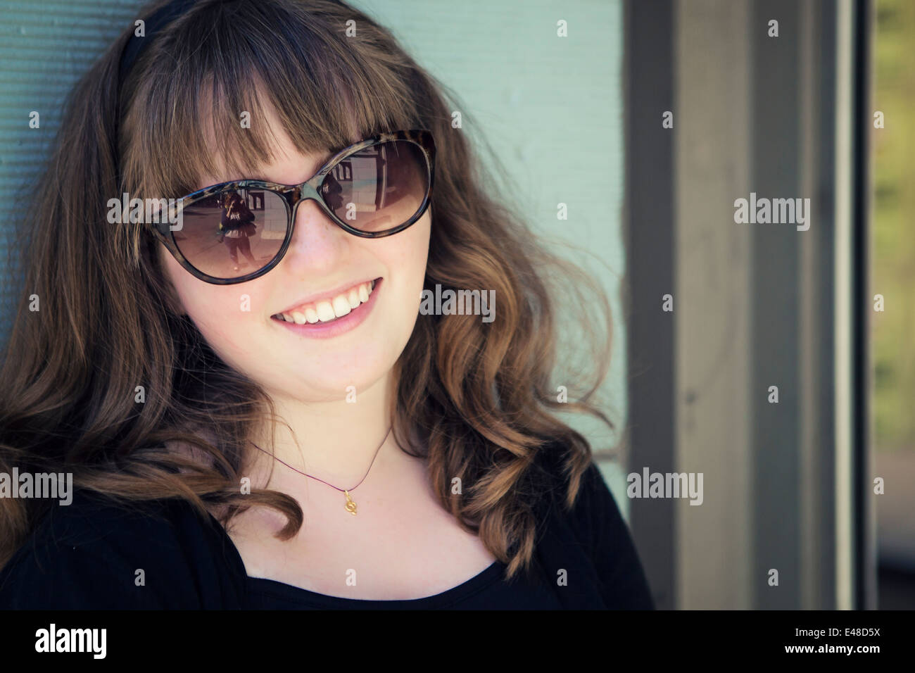 Portrait of smiling girl (13-15) in sunglasses Stock Photo