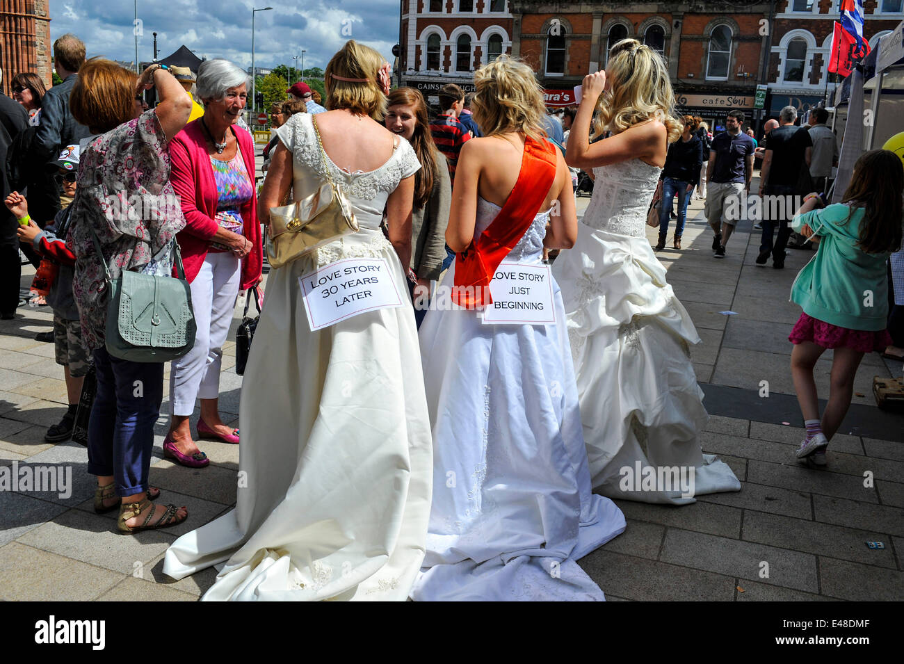 Derry, Londonderry, Northern Ireland UK, - 05 July 2014. Brides gather for world attempt. Some of the hundreds of, brides, of all ages, who walked across the Derry Peace Bridge, in an attempt to create a new world record for the number of brides gathered in one place. Last year 748 brides, including a few men, walked across the Peace Bridge to gain a place in the Guinness Book of Records. Credit: George Sweeney / Alamy Live News Stock Photo