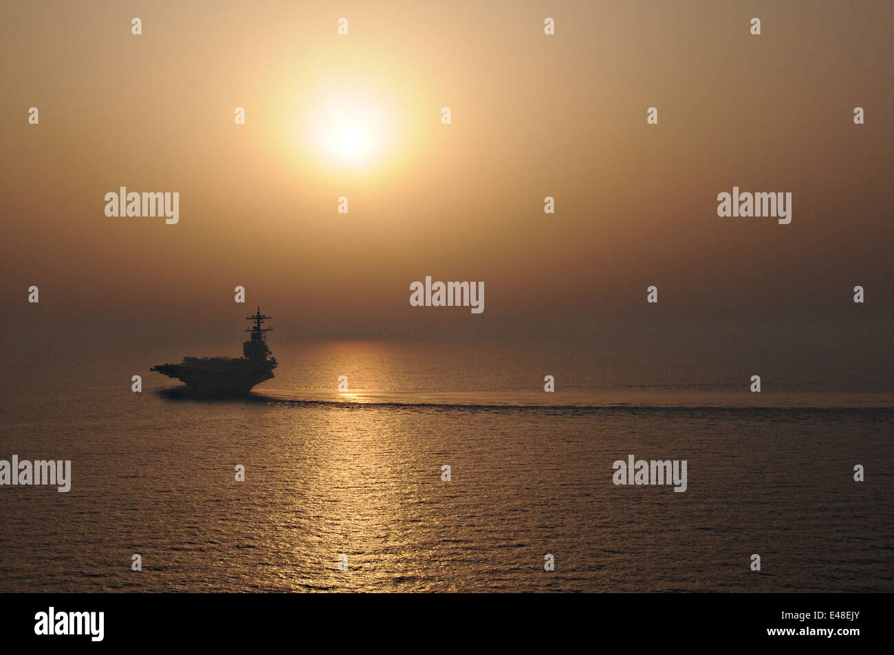 US Navy nuclear aircraft carrier USS George H.W. Bush during operations at sunset June 21, 2014 in the Persian Gulf. Stock Photo