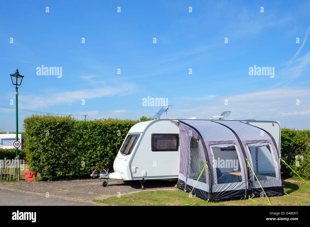 A touring trailer caravan with a porch awning sited on a hard standing on a quality camping park Stock Photo
