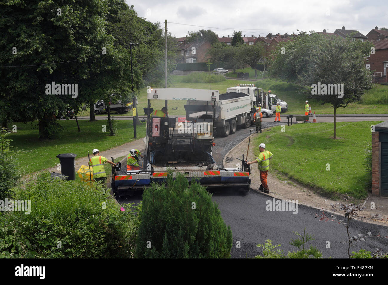 Road resurfacing work in a suburban street in Sheffield England. men working road repairs Stock Photo