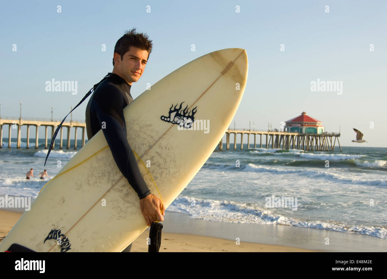 Surfer at Huntington Beach Pier in Orange County, CA Stock Photo