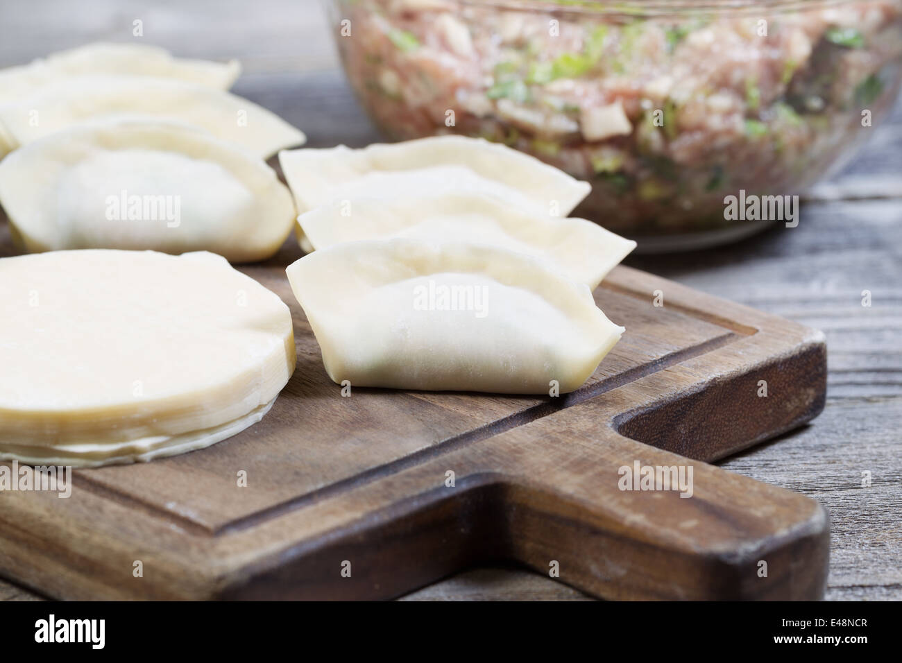 Closeup horizontal photo of homemade traditional Chinese Dumplings in wrappers being made from raw ingredients Stock Photo