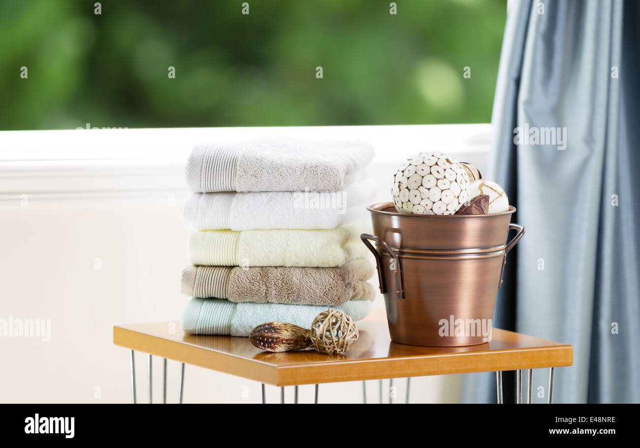 Spa accessories on top of table with open windows showing blurred green trees in background Stock Photo