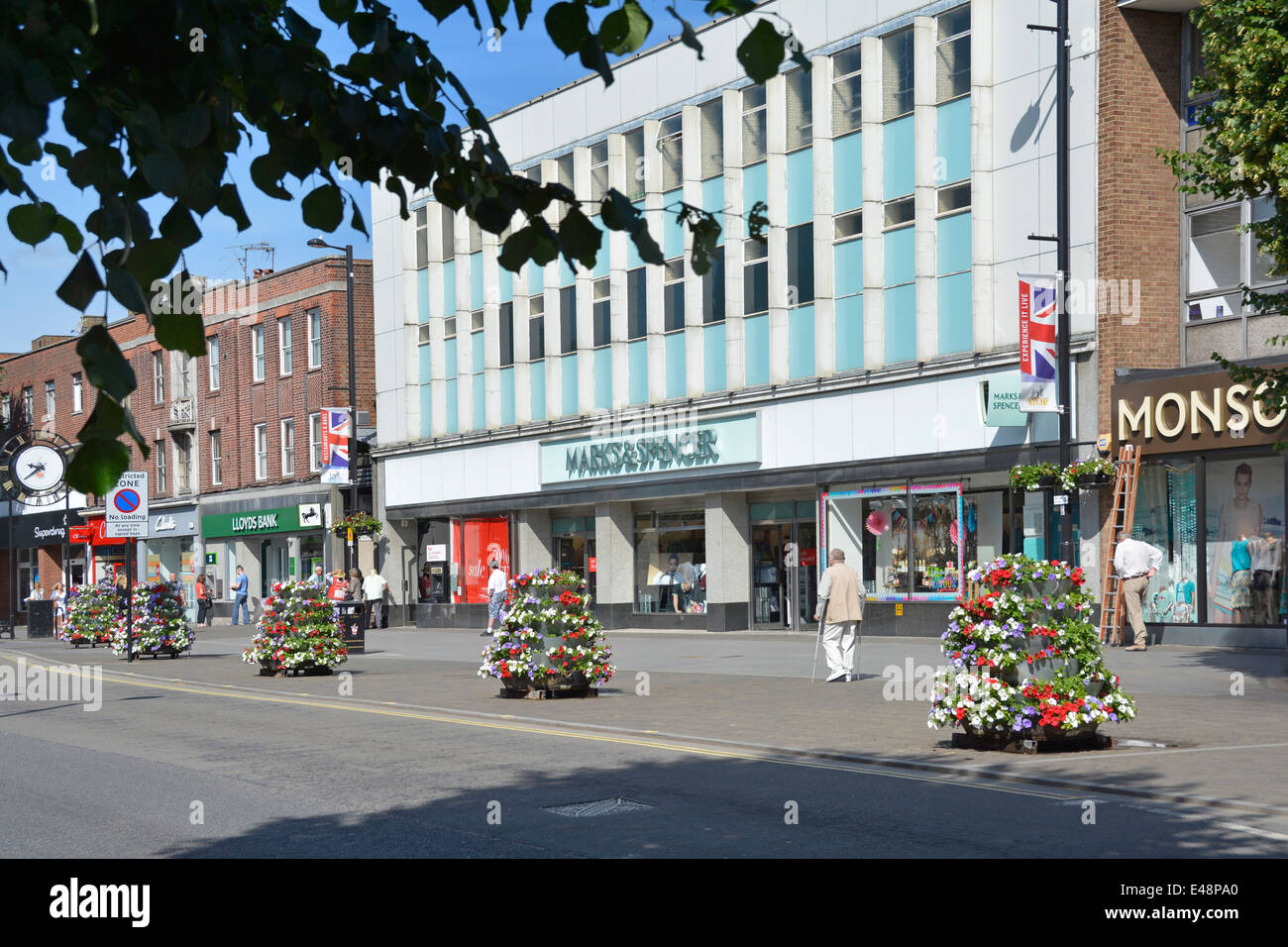 Marks and Spencers high street store with pavement floral decorations provided by local borough council Stock Photo