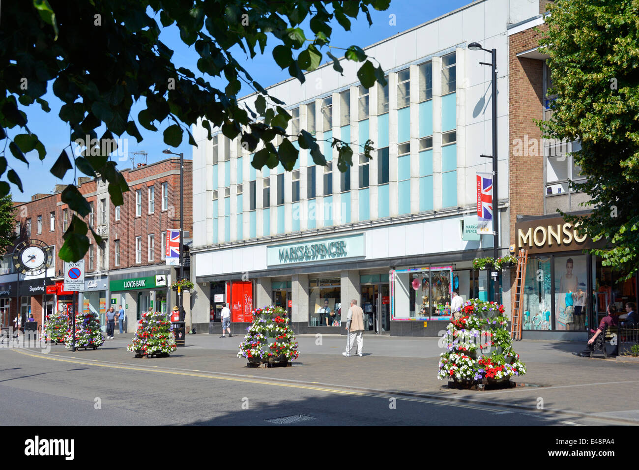 Marks and Spencers high street store with pavement floral decorations provided by local borough council Stock Photo