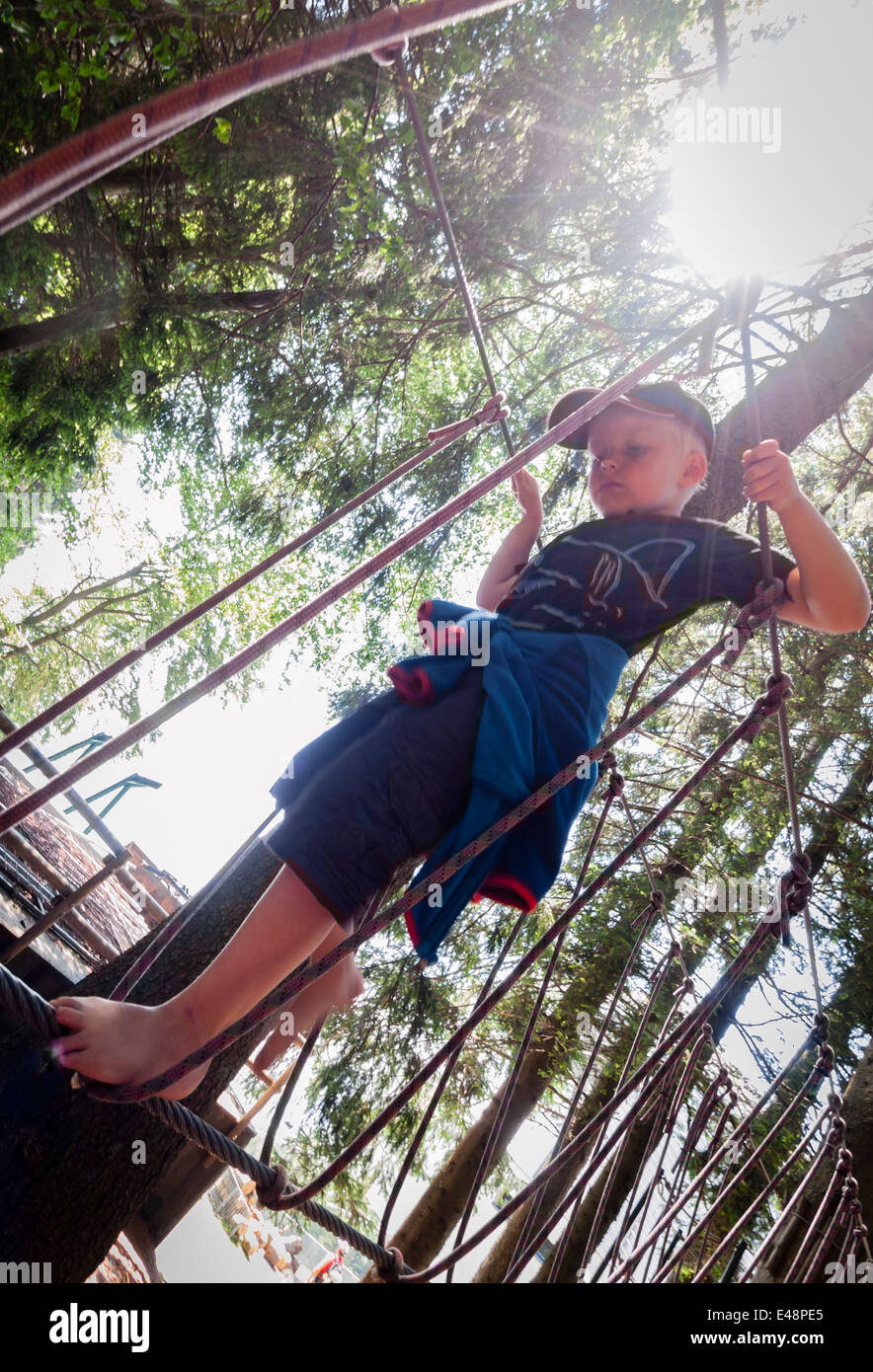 Boy balancing barefoot on rope in rope jungle gym Stock Photo Alamy