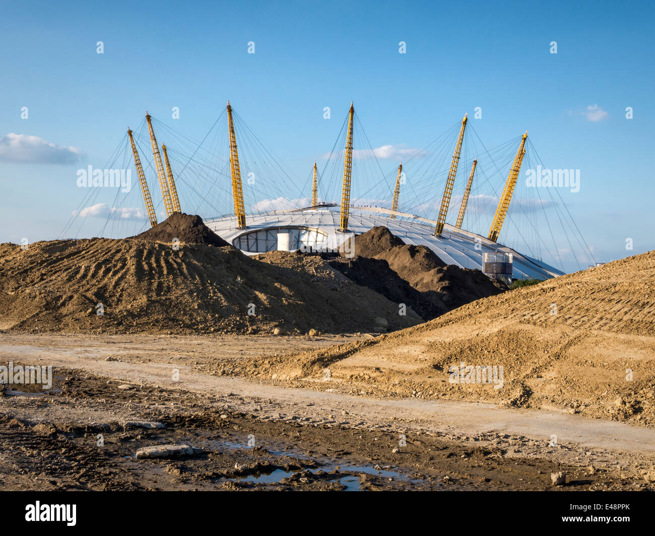 The 02 Arena behind an urban wasteland of piles of sand and building aggregates - Greenwich peninsula, London, UK Stock Photo