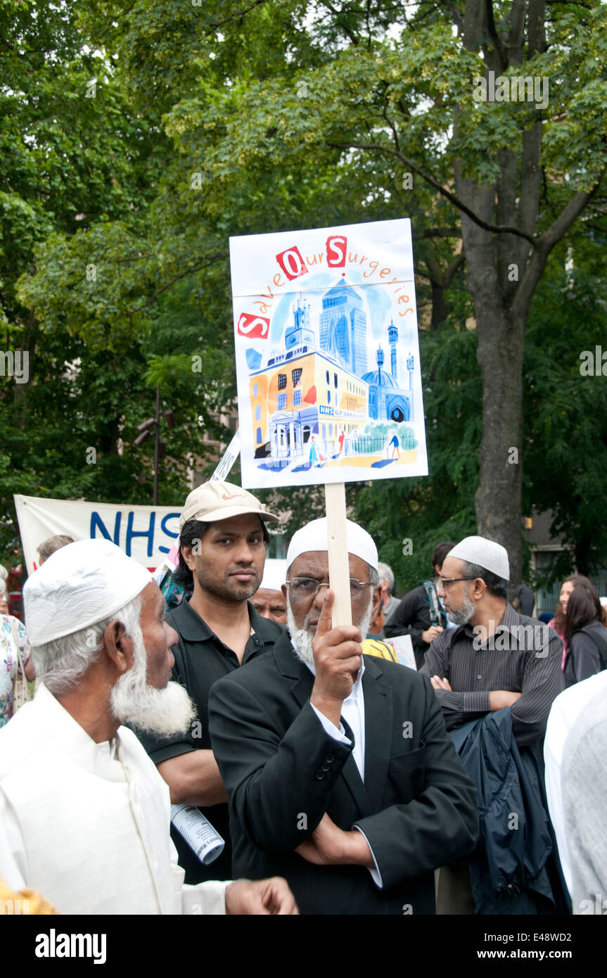 Muslim men at a rally and march against proposed cuts to National Health Service doctors' surgeries Stock Photo