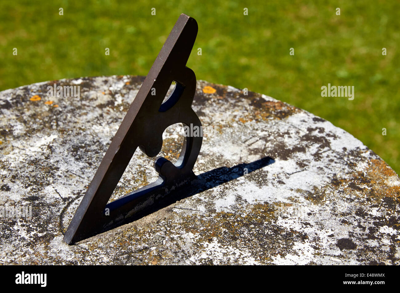 A small sun dial (or sundial) showing a solar time of 12:30 hrs. Stock Photo