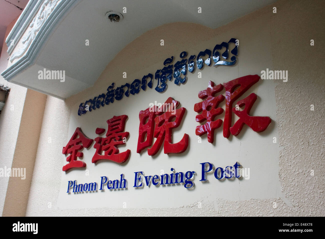 A sign on a wall written in Khmer and Chinese signifies the location of the Phnom Penh Evening Post in Phnom Penh, Cambodia. Stock Photo