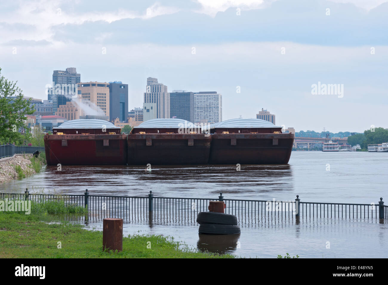 barges lined up on flooded banks of mississippi river in downtown saint paul minnesota Stock Photo