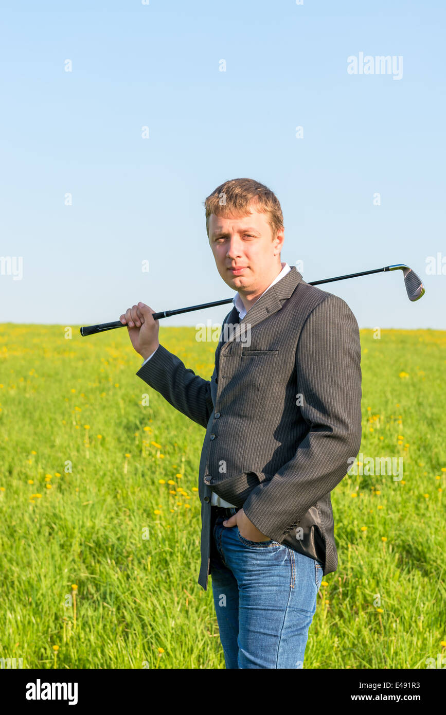 a man in a jacket and jeans going to play golf Stock Photo Alamy