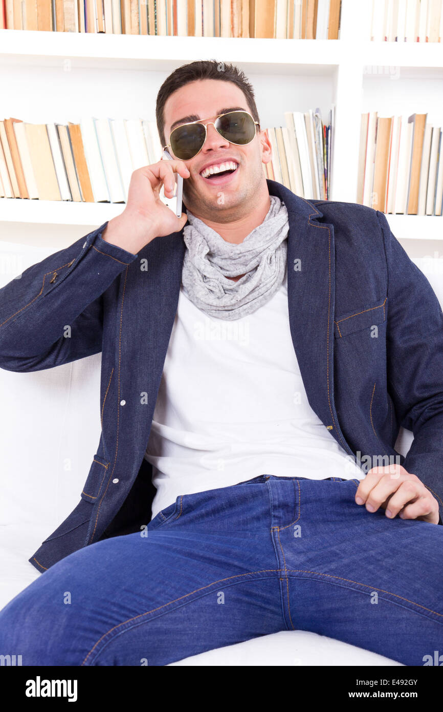 happy modern fashion man wearing sunglasses talking on the phone at home smiling Stock Photo