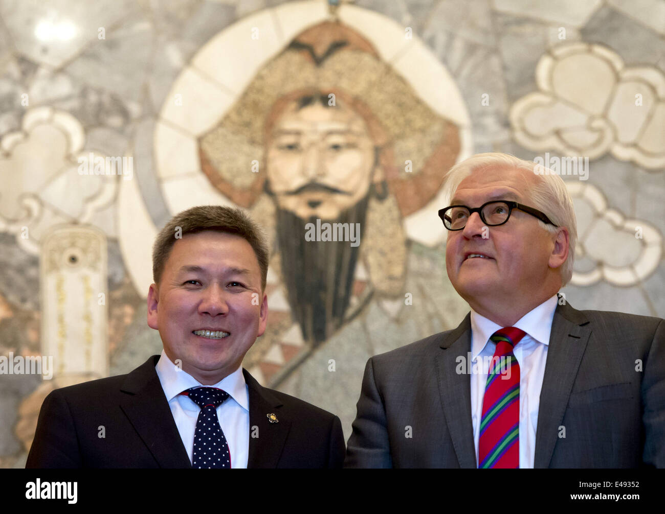 Ulan Bator, Mongolia. 6th July, 2014. German Foreign Minister Frank-Walter Steinmeier (SPD, R) and Mongolian Minister of Foreign Affairs, Luvsanvandan Bold, smile as they stand in front of an exhibited mosaic of Genghis Khan at the Mongolian Foreign Office in Ulan Bator, Mongolia, 6 July 2014. Steinmeier is on a two-day visit to Mongolia. PHOTO: SOEREN STACHE/dpa/Alamy Live News Stock Photo