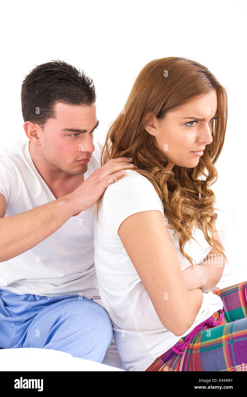 young pretty woman ignoring her man partner in her bed during a conflict, turning their back on each other Stock Photo