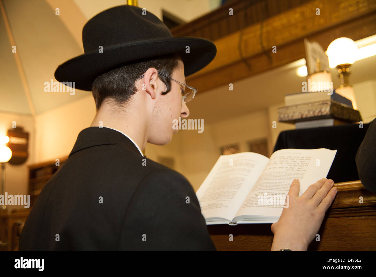 Orthodox Jewish man reads the Megillah 'The Scroll of Esther' during the Jewish festival of Purim. Stock Photo