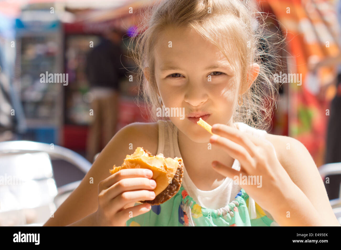 Girl having the lunch at a fast-food restaurant Stock Photo