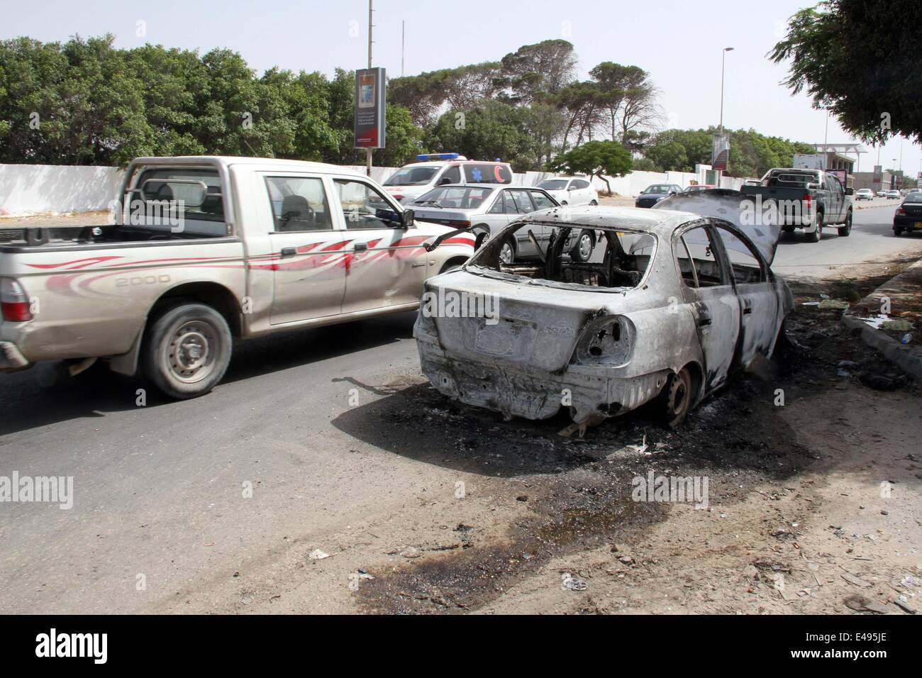Tripoli, Libya. 6th July, 2014. The picture taken on July 6, 2014 shows a damaged car in Janzour area of Tripoli, Libya. Heavy fighting erupted in the Libyan capital city of Tripoli since the early hours of Sunday between the Interior Ministry's auxiliary security forces and a militia group called 'Knights Battalion', killing one person and injuring three others. (Xinhua/Hamza Turkia) Stock Photo