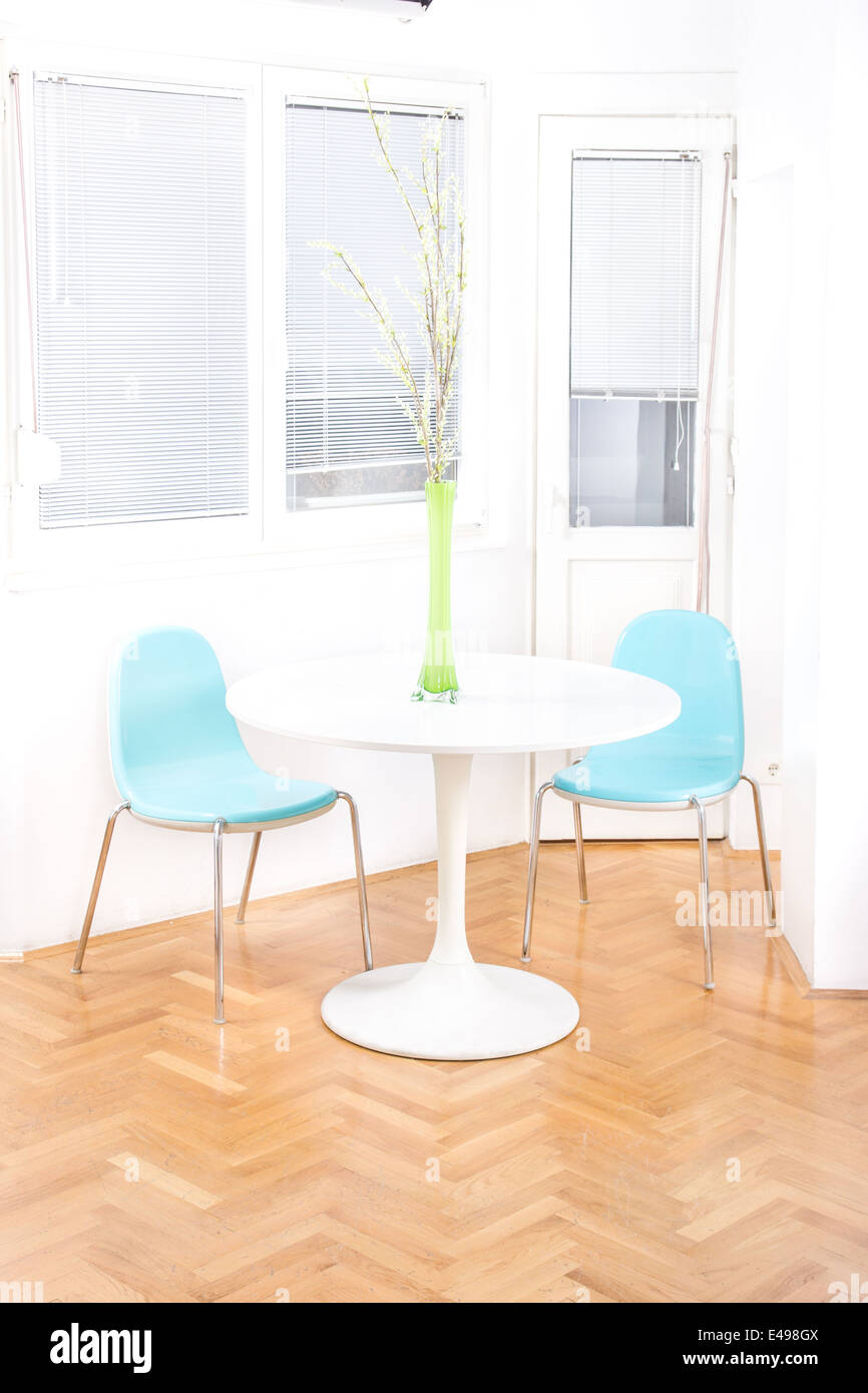 central table with flower in front of windows in dining room, home