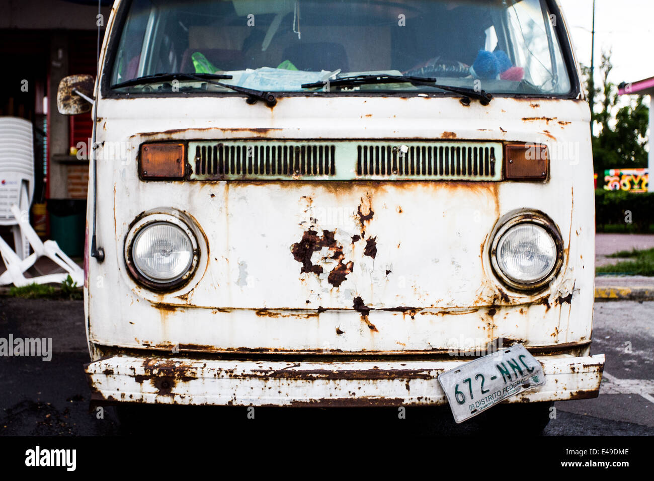 Front of a white Old VW bus, rusty and falling a part Stock Photo