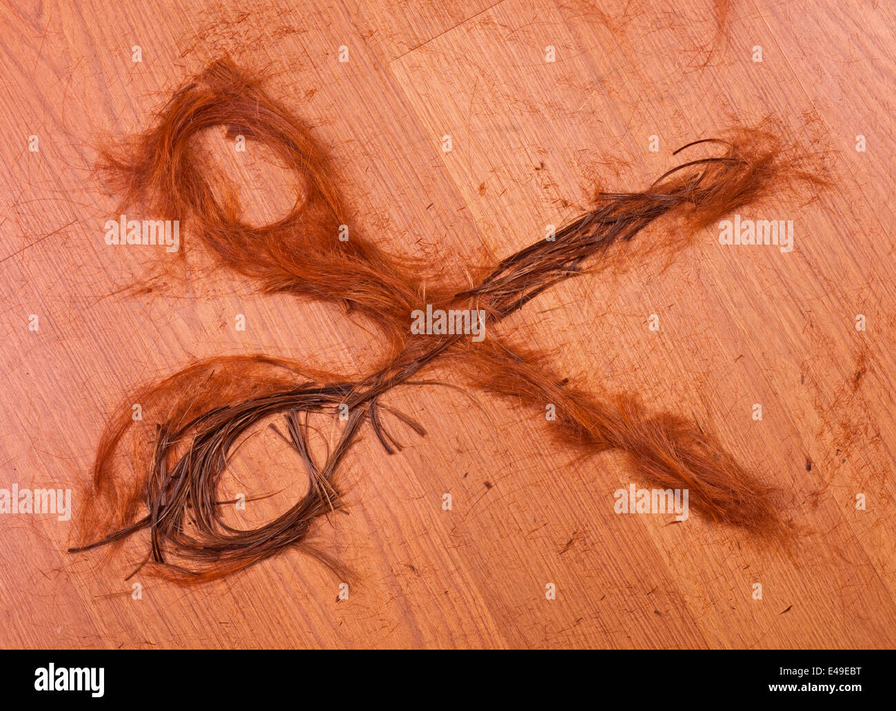 cropped hair in the form of scissors on wooden background Stock Photo