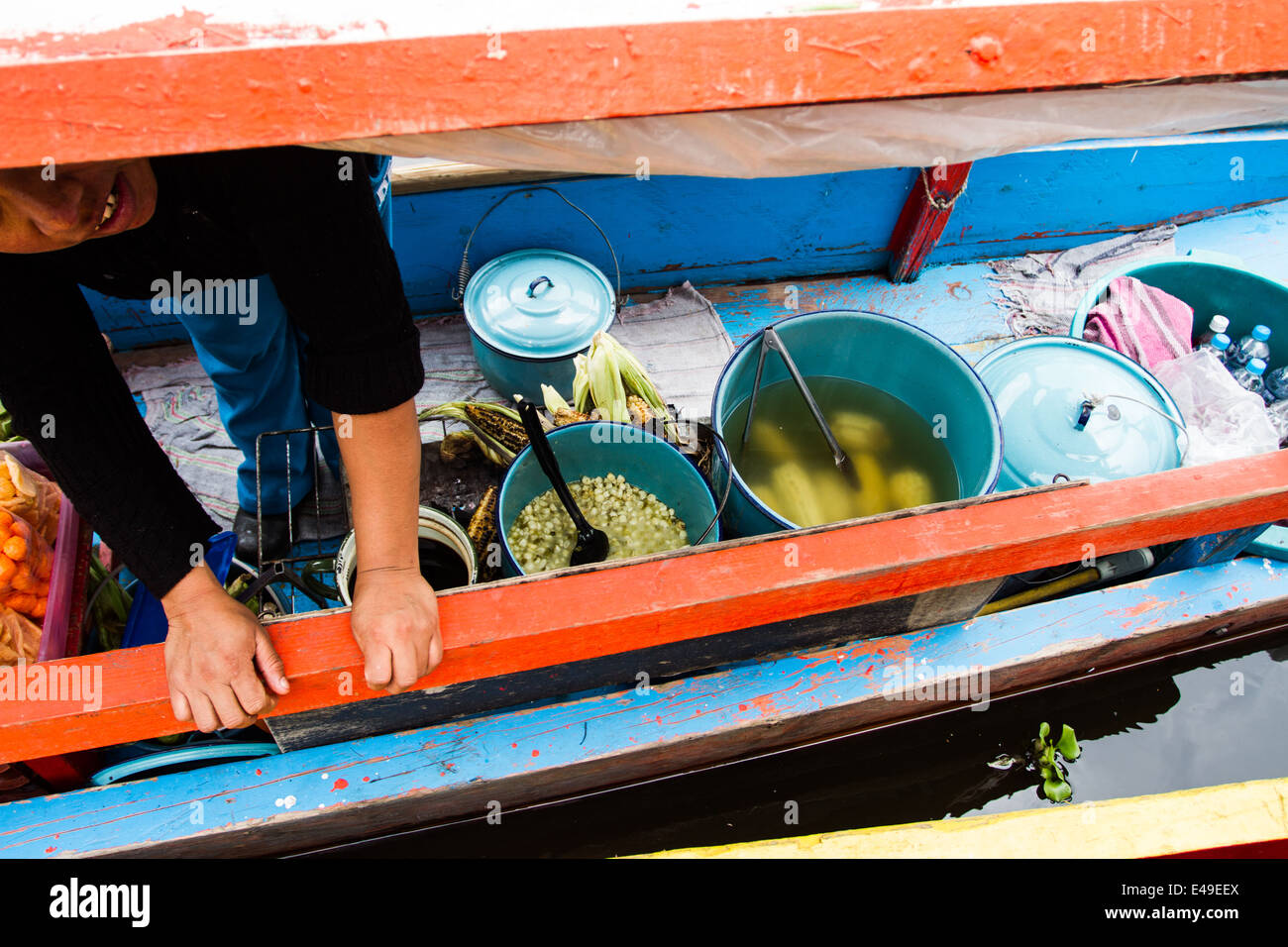 Woman prepares fresh corn on a floating shop Stock Photo