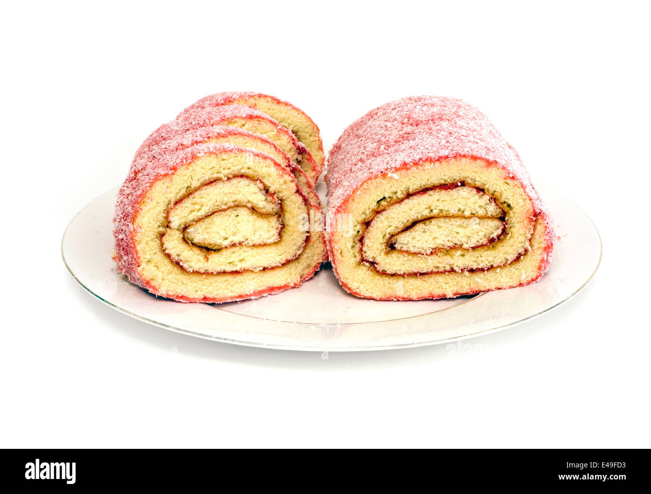 Jelly roll cut in half on plate against white background Stock Photo
