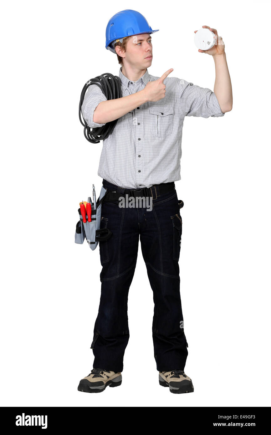 Tradesman pointing to a smoke detector Stock Photo