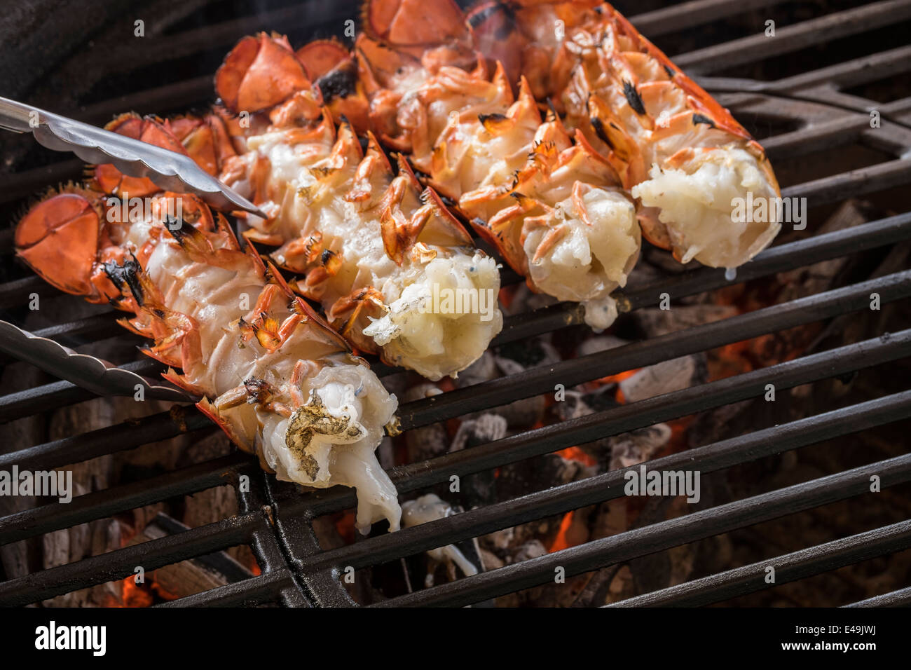 Lobster tails cooking over charcoal on barbecue grill Stock Photo Alamy