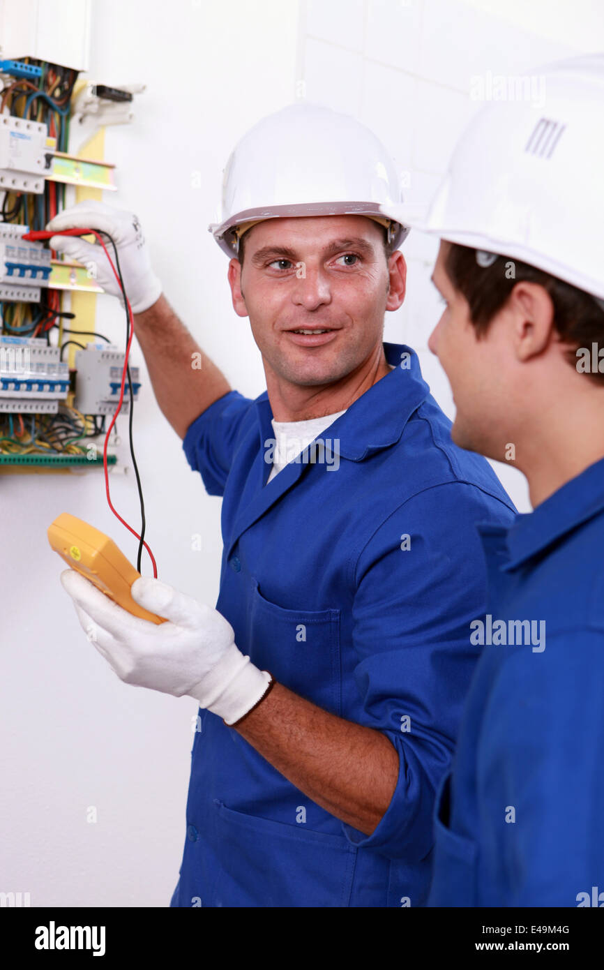 Two electricians testing fuse box Stock Photo