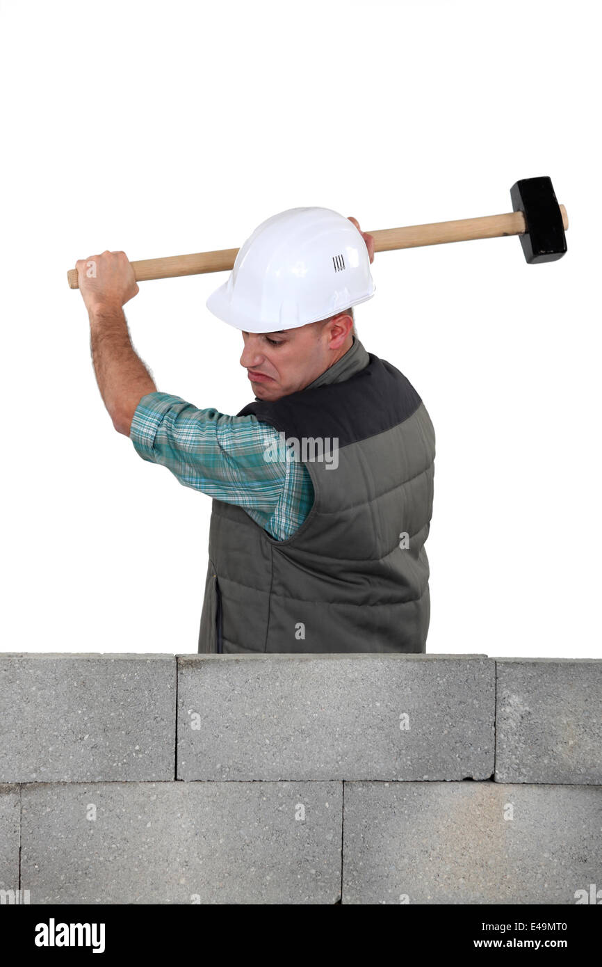 Man hitting a wall with a sledgehammer Stock Photo Alamy