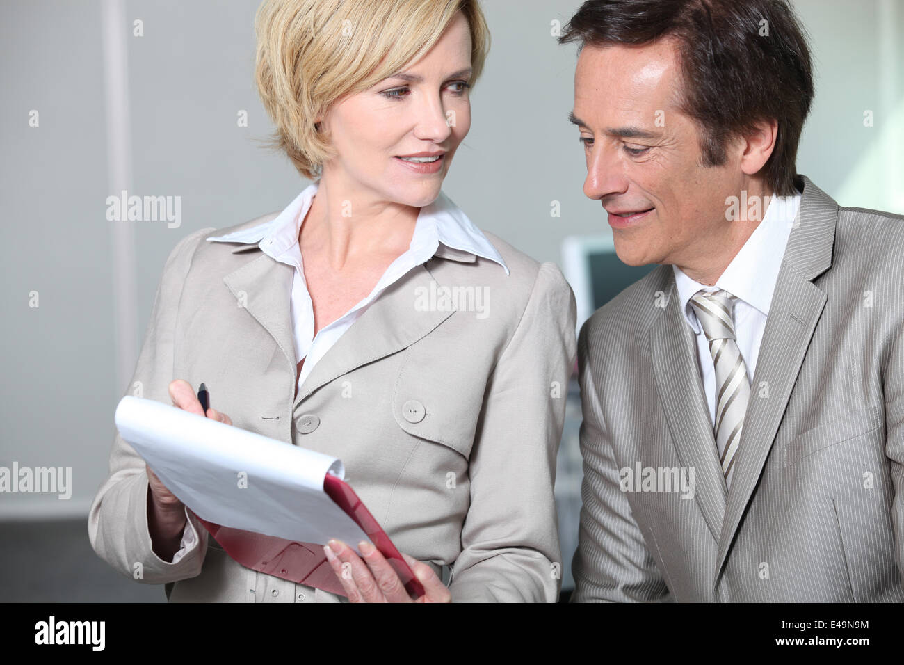 Business colleagues looking at clipboard. Stock Photo