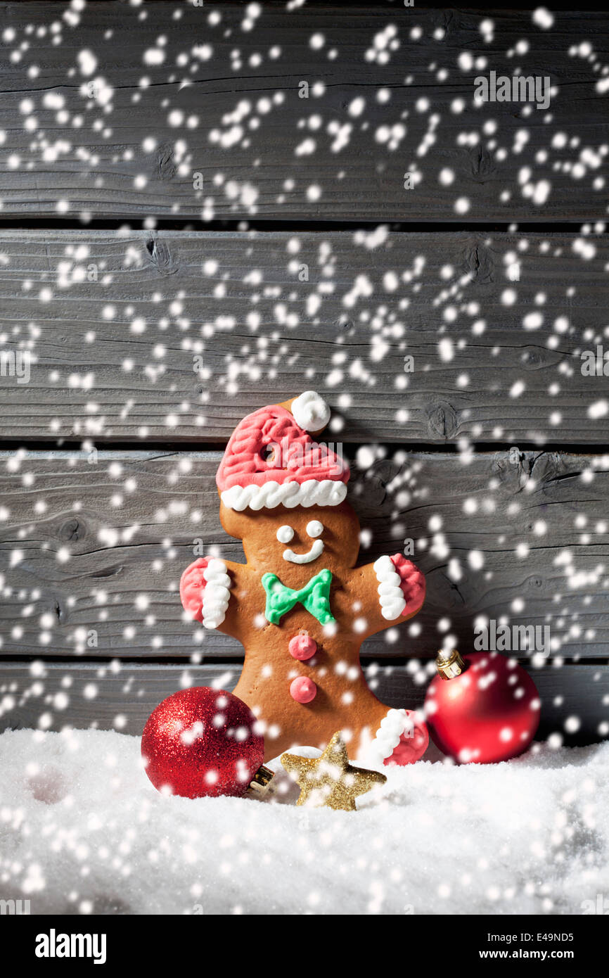 Gingerbread man and Christmas bubbles  with rippling artificial snow in front Stock Photo