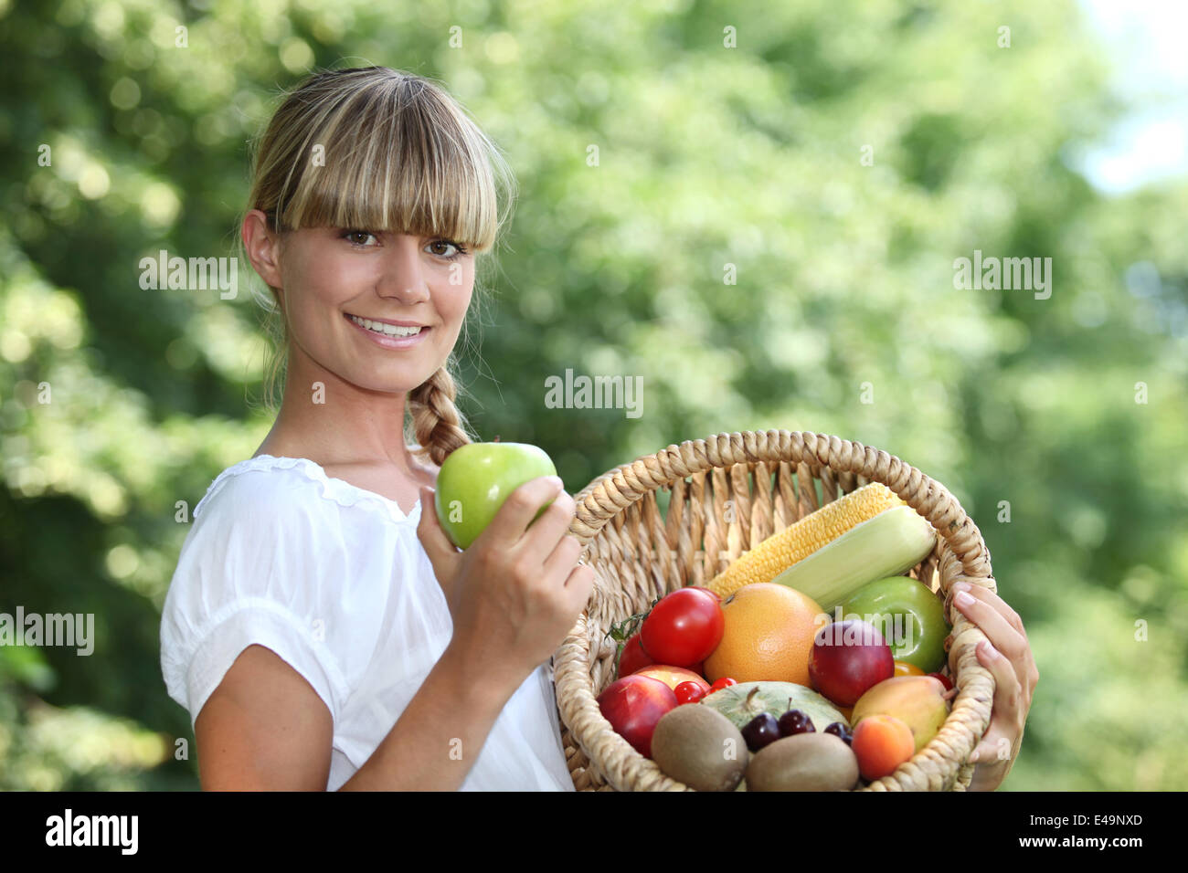 Woman holding a basket of fruit Stock Photo - Alamy