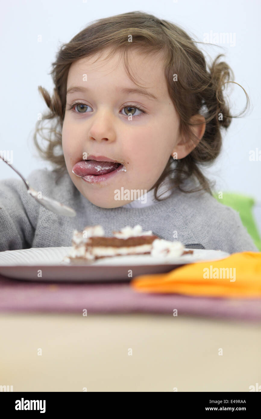 Young girl eating a piece of cake Stock Photo Alamy